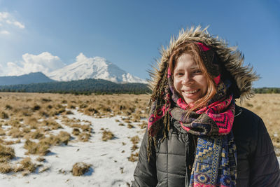 Portrait of young woman standing in field