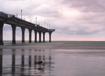 Bridge over sea against sky during sunset