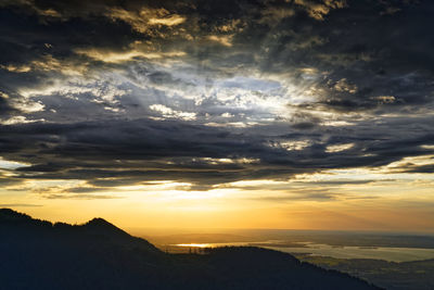 Scenic view of dramatic sky over silhouette landscape