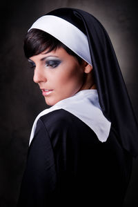 Close-up of nun against black background