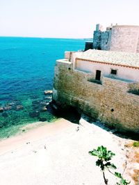 High angle view of castle by sea against sky