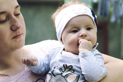 Close-up of mother holding daughter outdoors