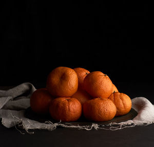 Close-up of oranges on table against black background