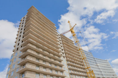 House of concrete and metal, modern technology, a skyscraper on a background of blue sky.