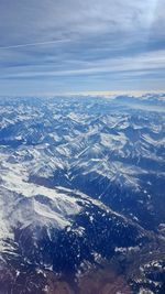 Aerial view of snowcapped mountains against sky