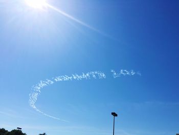 Low angle view of vapor trail against blue sky