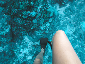 Low section of woman wearing diving flipper in water