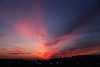 Silhouette landscape against dramatic sky during sunset