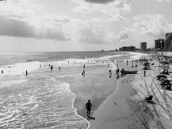 People standing on beach against sky