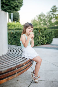 Portrait of smiling girl sitting outdoors