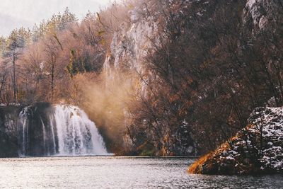 Scenic view of waterfall in forest during winter