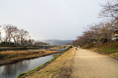 Road by river against clear sky