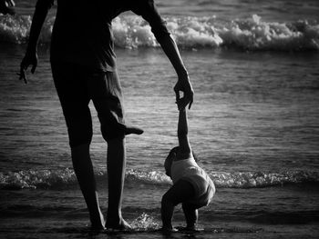 Rear view of man and holding child at beach