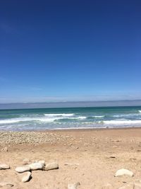 Scenic view of beach against clear blue sky