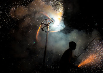 Silhouette man standing against sky at night