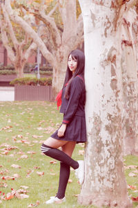 Full length portrait of woman against tree