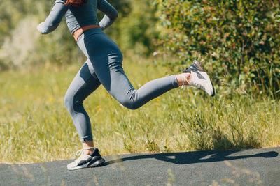 Low section of woman running on road