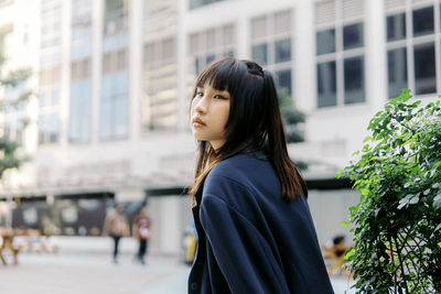 Young woman looking away in city