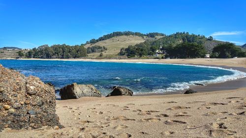 Scenic view of beach against blue sky
