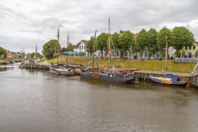 Boats moored at harbor against sky