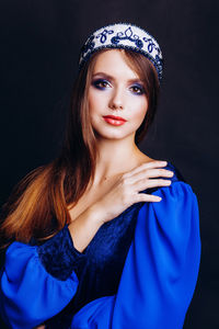 Close-up of beautiful woman in traditional clothing against black background