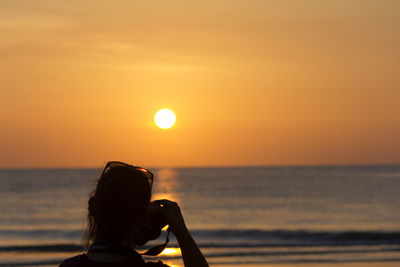 Woman against sea during sunset