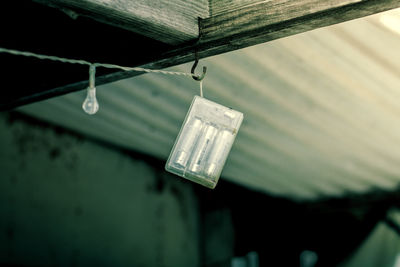 Close-up of light bulb hanging from roof