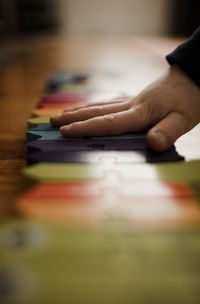 Preschooler boy's hand putting together a brightly colored puzzle