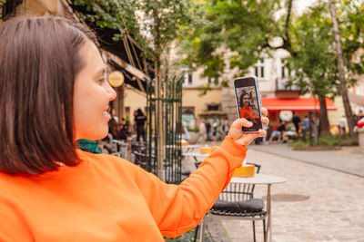 Side view of young woman using mobile phone