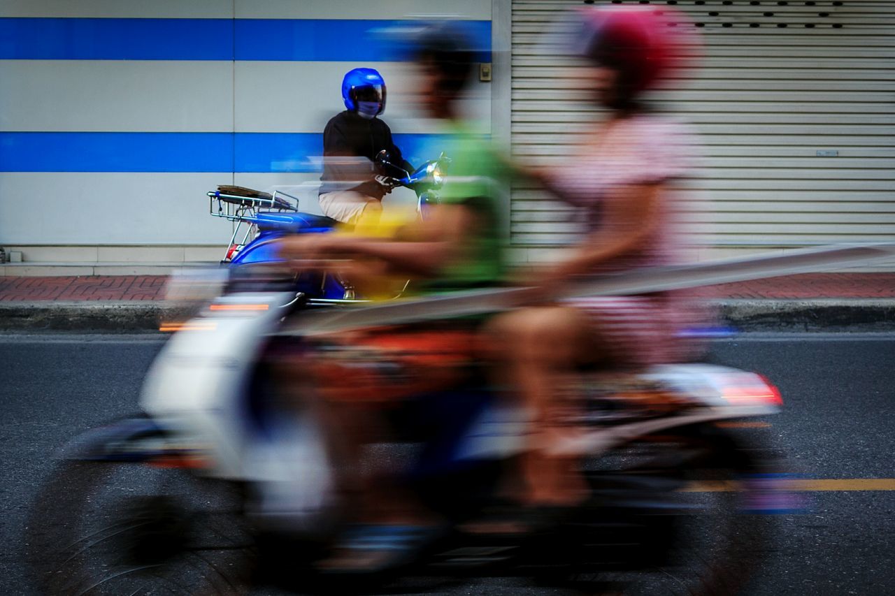 lifestyles, blurred motion, motion, transportation, men, street, leisure activity, on the move, speed, city life, walking, land vehicle, road, mode of transport, person, full length, bicycle, riding, city