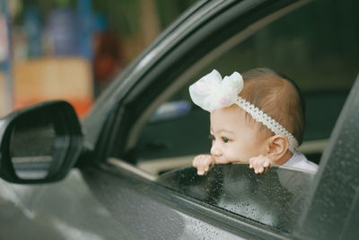 Cute boy looking through car window