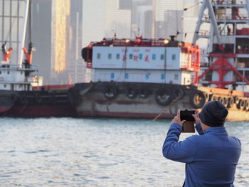 Rear view of woman photographing sea