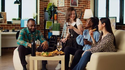 Portrait of young woman using mobile phone while sitting on table