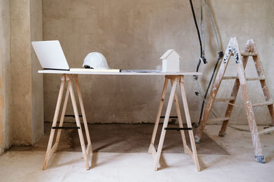 Blueprints, protective helmet, laptop,house model and tools on architect workspace.construction site