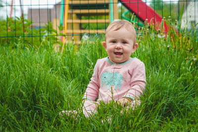 Portrait of cute girl sitting on grass