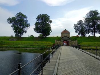 Footpath by railing against sky