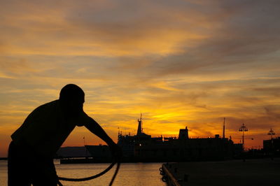 Silhouette of man in city during sunset