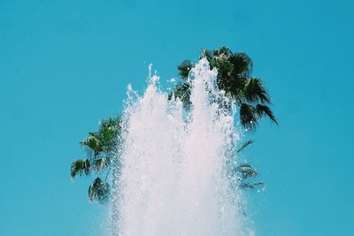 Low angle view of fountain against clear blue sky