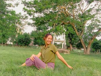 Portrait of young woman sitting on field