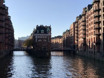 Bridge over river amidst buildings in city