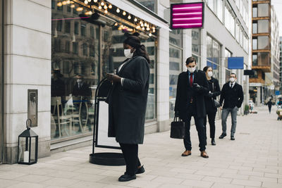 People walking on footpath in city