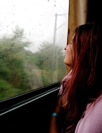 Woman looking through window in train