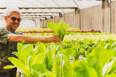 Low angle view of young man standing amidst plants