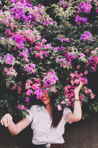 Midsection of woman standing by pink flowering plants