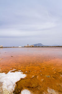 Landscape scenic view of salt flats, with windmills and a mountain in the background