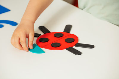 Cropped hand of woman holding dices against white background