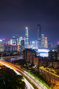 Illuminated buildings in city against sky at night