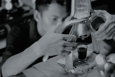 High angle view of man taking espresso shot from machine