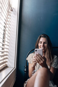Woman on video call while sitting by window