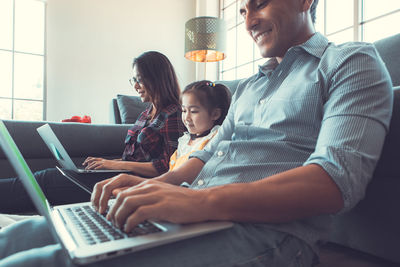 Rear view of siblings sitting on laptop